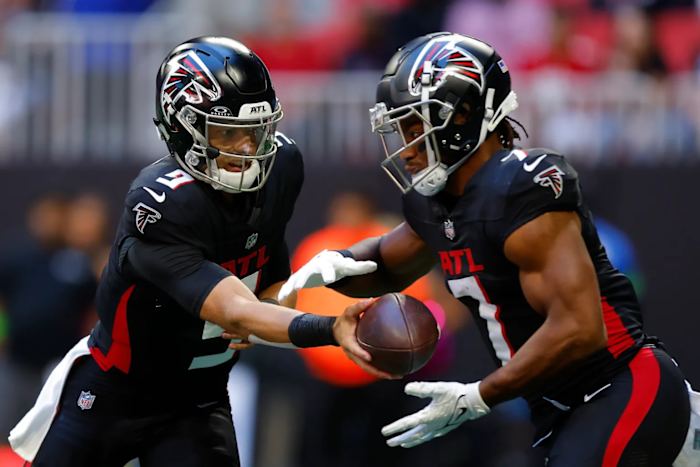 Atlanta Falcons quarterback Desmond Ridder hands off to running back Bijan Robinson.